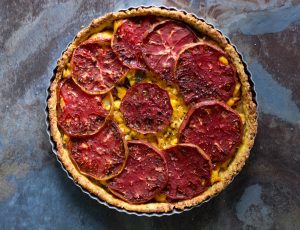 Baked-heirloom-tomato-and-ackee-tart-in-aged-cheddar-thyme-crust