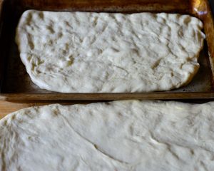 half-focaccia-dough-spread-in-pan-before-filling