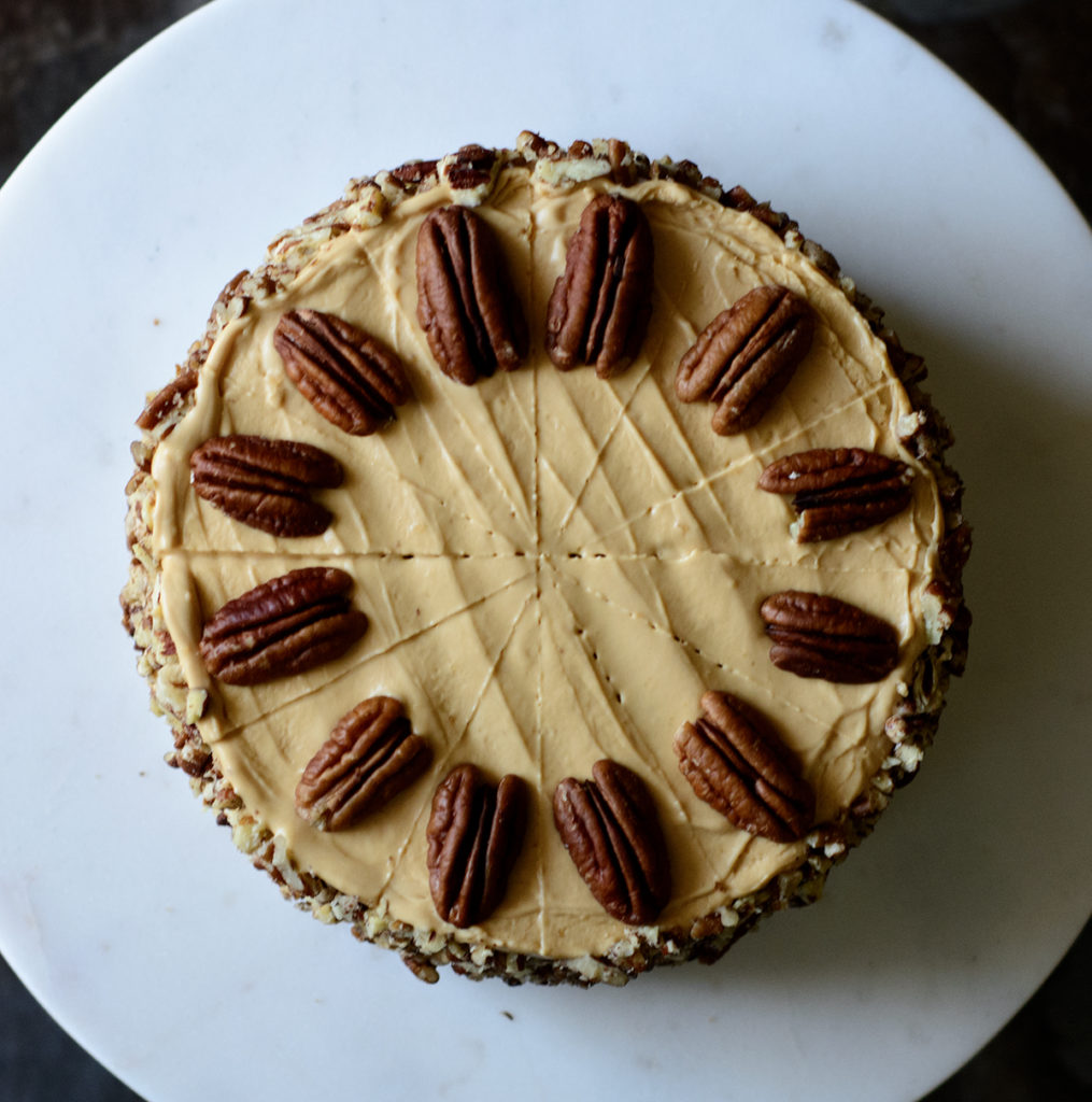 top-view-of-the-brown-sugar-ackee-cake-with-dulce-de-leche-frosting-and-toasted-pecans