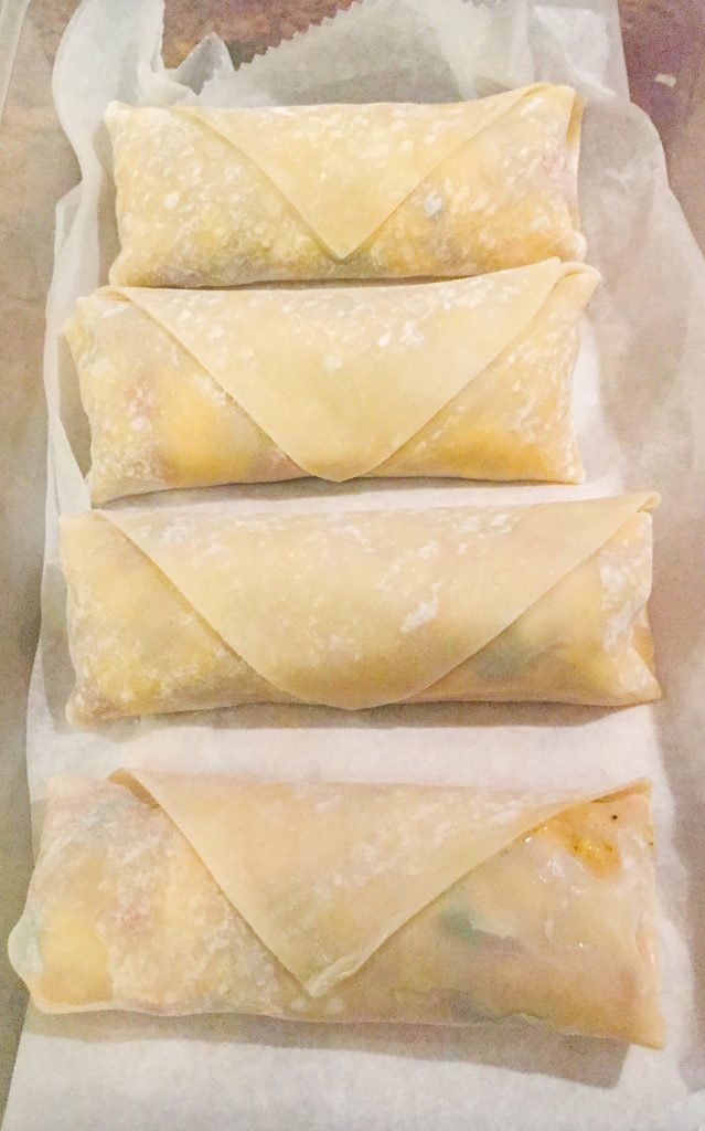 how-to-make-ackee-and-saltfish-springrolls-step-6-stack-the-springrolls-between-pieces-of-parchment-if-not-frying-right-away-roll-in-cornstarch-to-keep-exterior-crispy-and-juice-from-oozing-out
